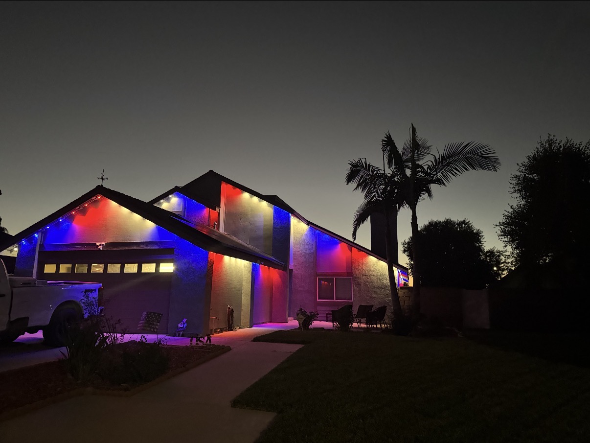 Red, white, and blue permanent fascia lighting installed on a single-story home